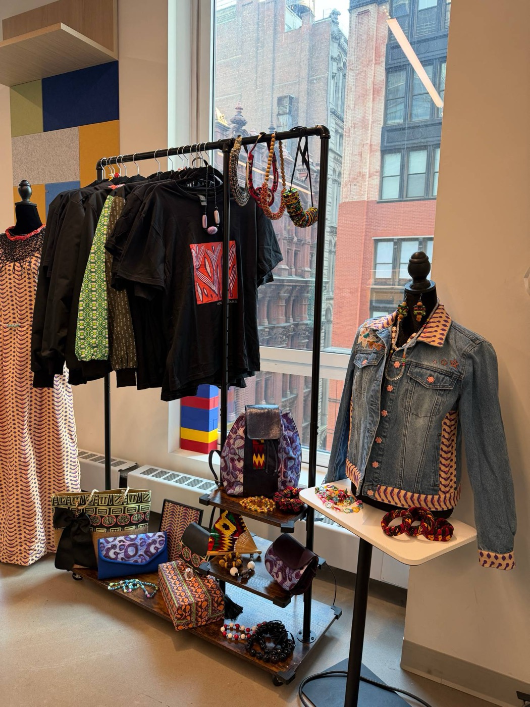 Detail of the collection: printed t-shirt, denim jacket with wax print trim, bags and beaded jewelry